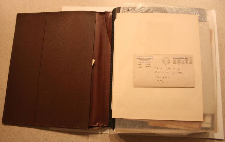 Brown binder containing book jackets, notecards, and illustration reproductions