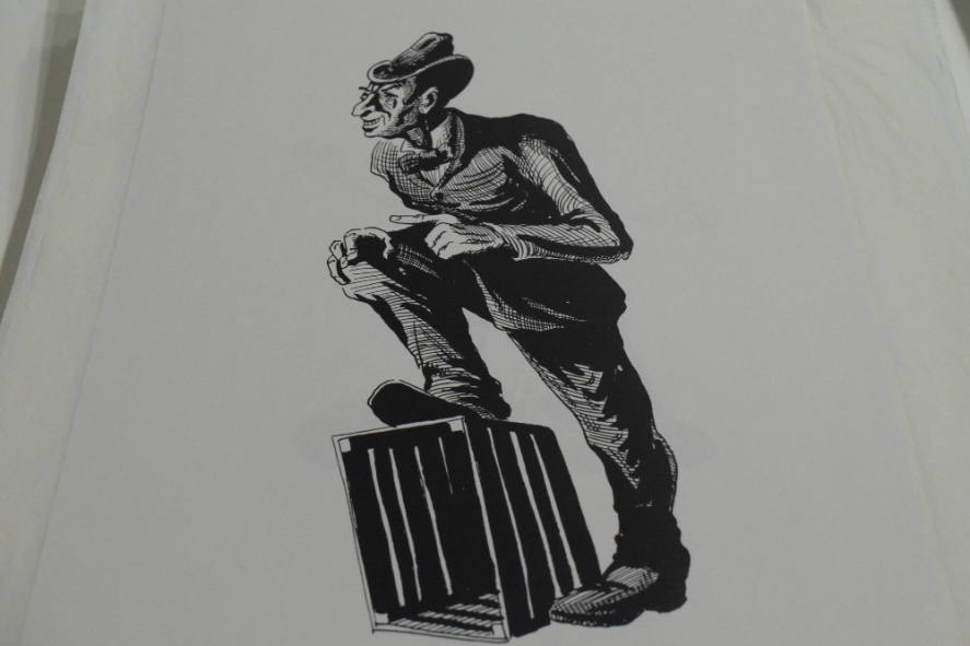 Man with hat and foot on crate